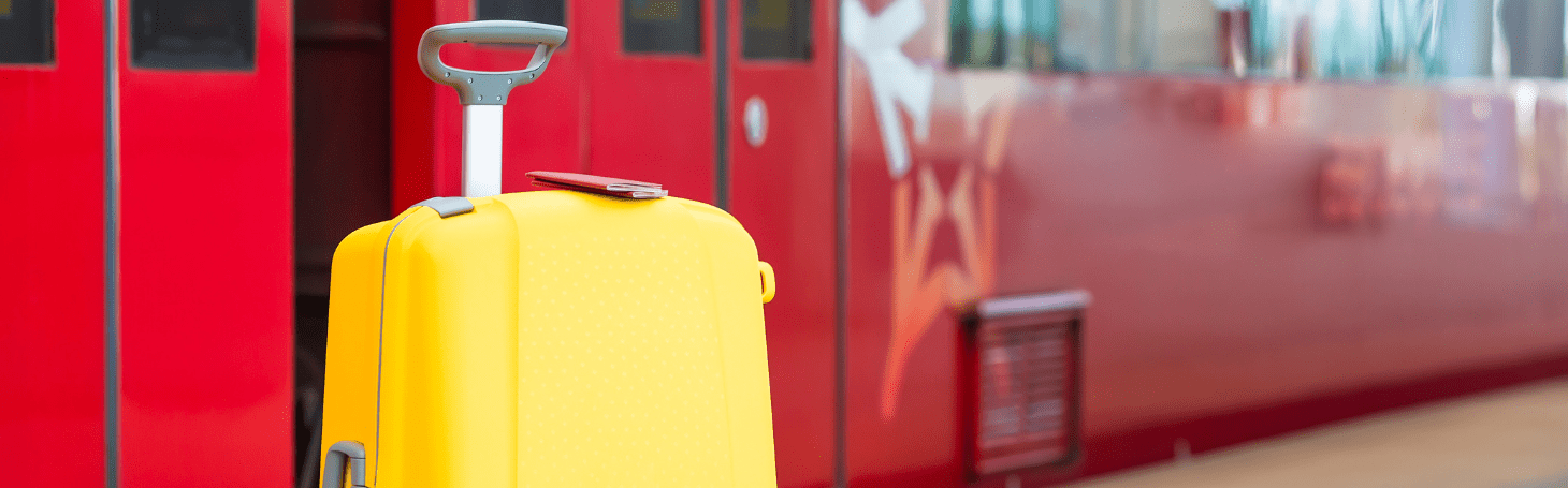 Bagaż ponadwymiarowy PKP Intercity - zasady przewozu dużego bagażu walizka na tle pociągu - Bagaż ponadwymiarowy PKP Intercity - zasady przewozu dużego bagażu