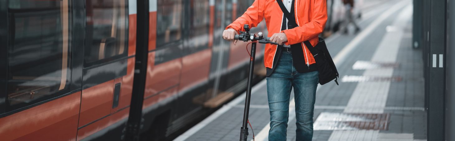 Hulajnoga elektryczna w pociągu Mężczyzna z hulajnogą elektryczną przy pociągu