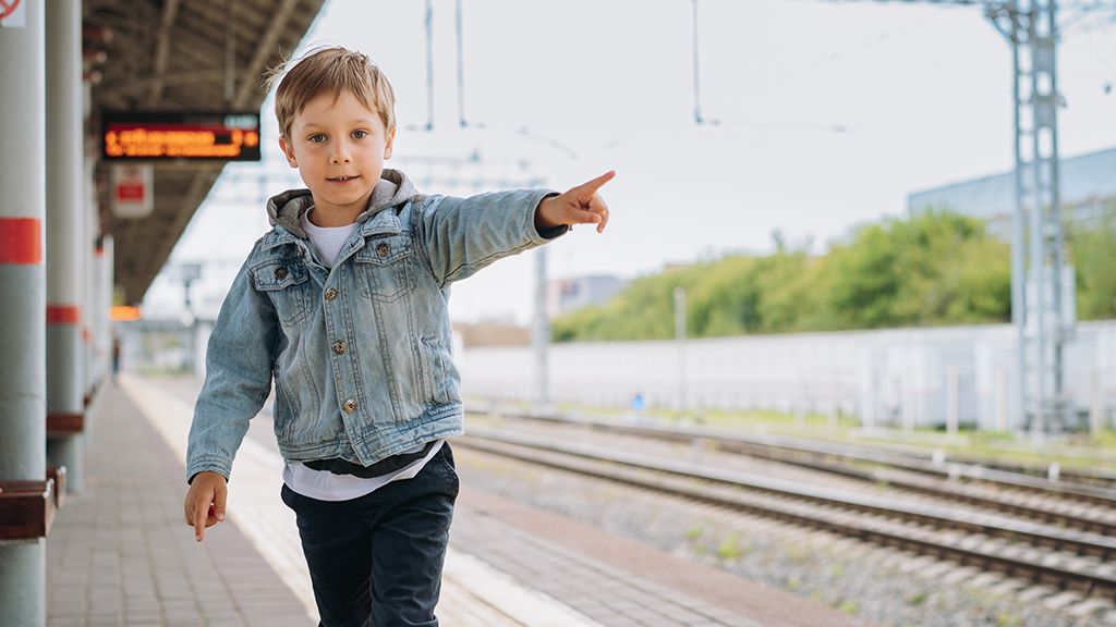 Zniżki dla dzieci w PKP Dziecko wskazujące drogę na peronie - zniżki dla dzieci w PKP