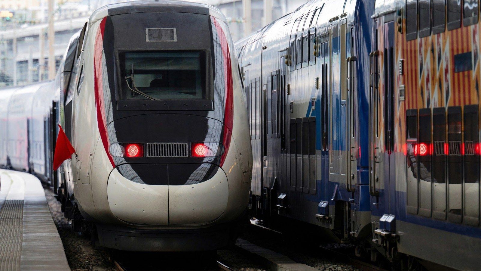Pociągi różnych przewoźników na stacji Pociąg dużych prędkości TGV i pociągi regionalne na sąsiednich torach stacji