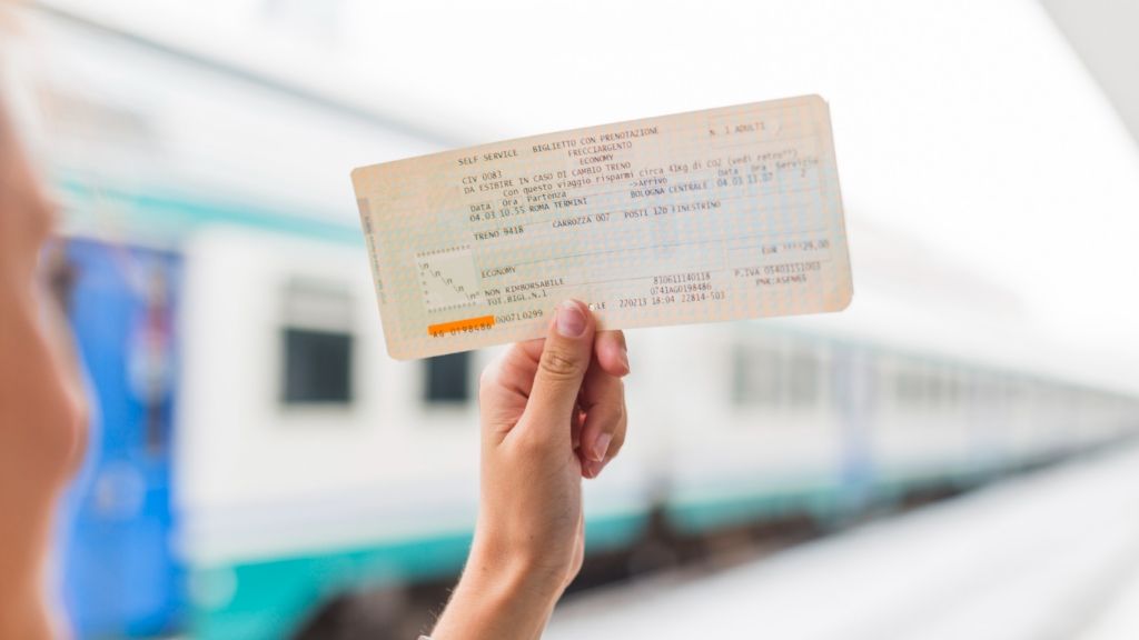 Ulgi i zniżki w PKP Kobieta trzymająca bilet w ręku