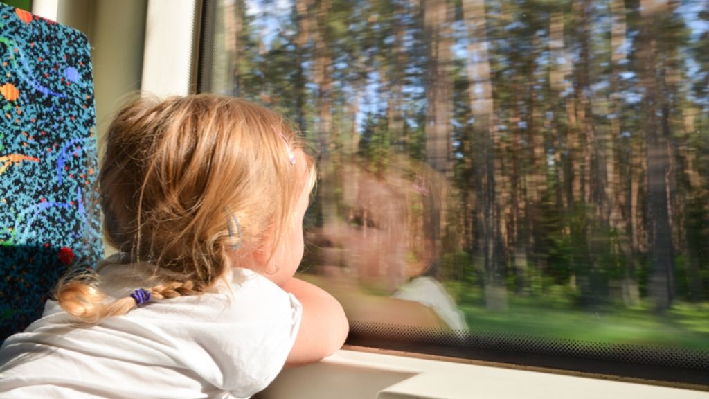 Czy kolej jest ekologicznym środkiem transportu? Dziewczyna w wagonie patrząca przez okno