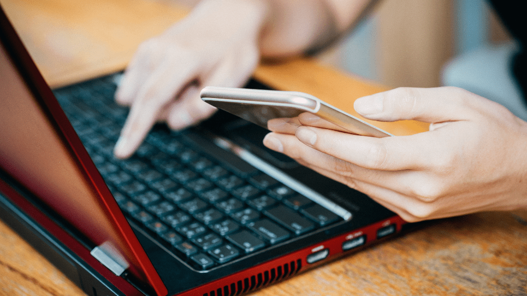 Czas serwisowy i przerwa techniczna PKP – ile trwa i co warto wiedzieć? Osoba używająca laptopa i telefonu