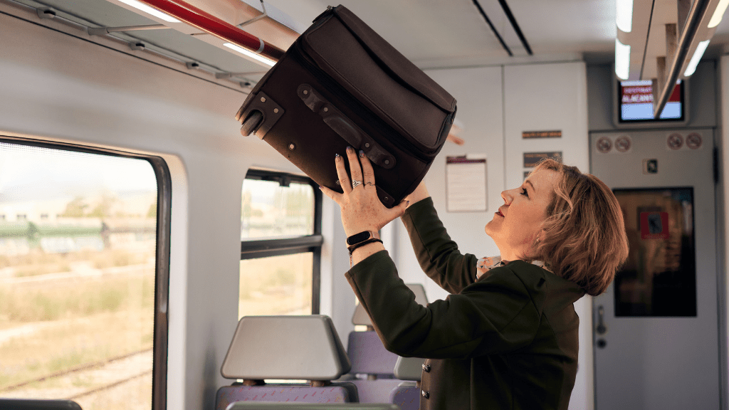 Bagaż ponadwymiarowy PKP Intercity kobieta wkładajaca walizkę w pociagu